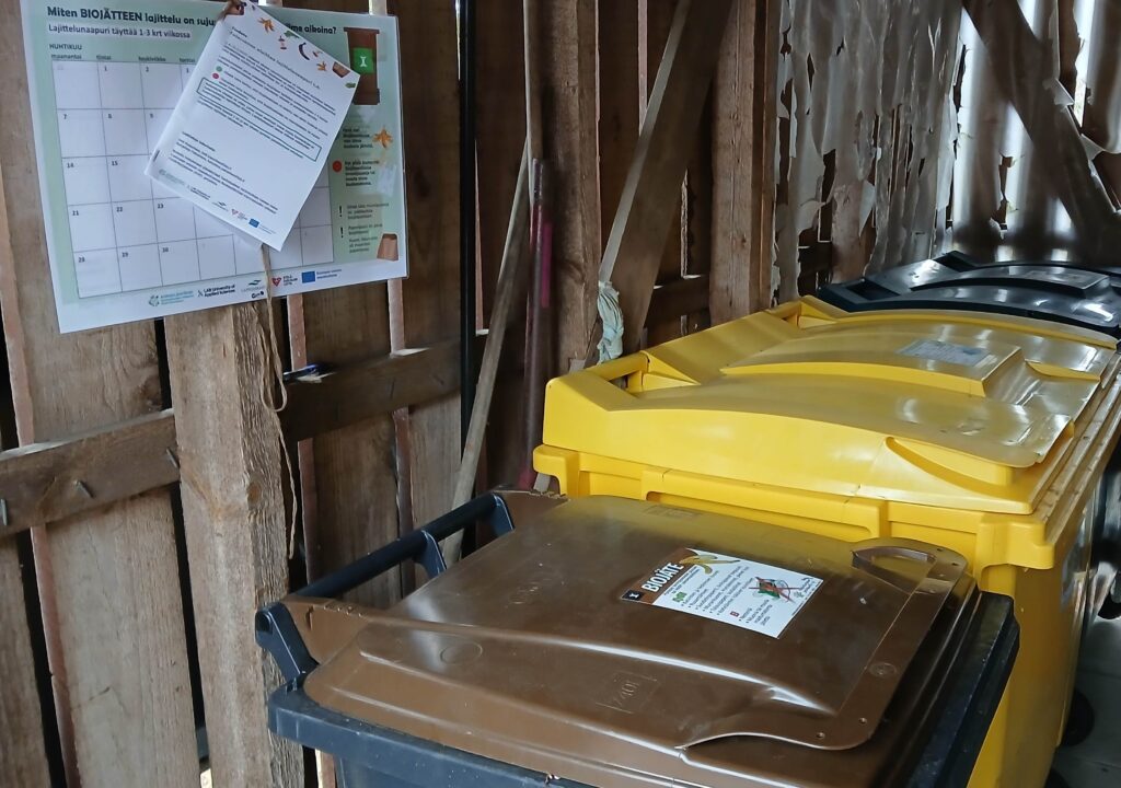 Lajittelunaapurin kalenteri jätekatoksessa