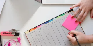 Projektityön arkea kuvaavat muistilaput, korostustussi, kansion välilehdet