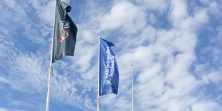 LABin ja LUTin liput liehuvat salossa sinistä taivasta vasten