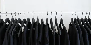 Mustia vaatteita henkareilla.