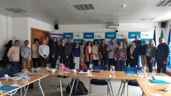 A group of people standing along the wall