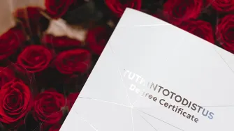 LABin tutkintotodistus ruusujen päällä.