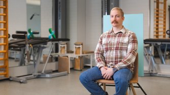 LABin fysioterapeuttiopiskelija Juuso-Ville Rautiainen istuu tuolilla luokkatilassa, jossa fysioterapeuttiopiskelijat opiskelevat.