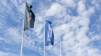 LABin ja LUTin liput liehuvat salossa sinistä taivasta vasten