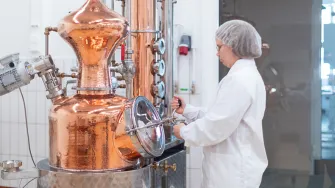 Nainen laboratoriossa uuttolaitteen edessä