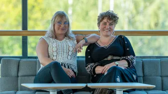 Minna Ahlsten ja Ilona Tuomi istumassa sohvalla 