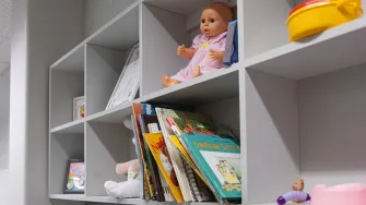 Pienten lasten leluja seinällä hyllyillä