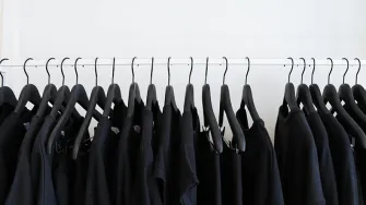 Mustia vaatteita henkareilla.