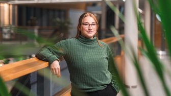 LAB-ammattikorkeakoulun opiskelija Essi Jäkälä nojaa kampuksella kaiteeseen ja katsoo kameraan.