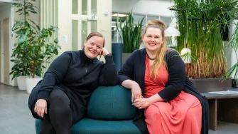 Kaksi opiskelijaa kampuksen aulassa