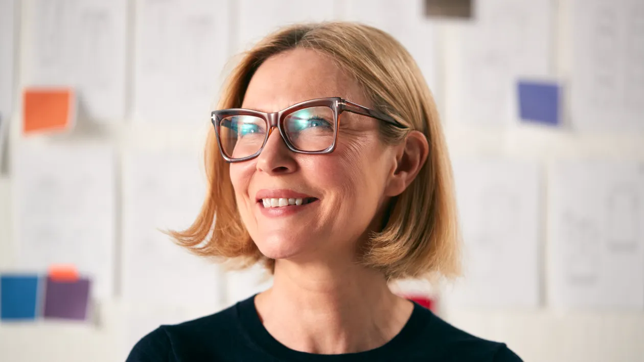 portrait-of-mature-woman-standing-in-front-of-desi