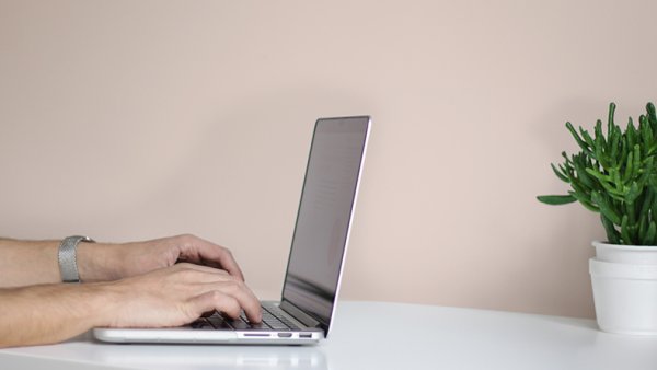 Laptop and a light beige wall.