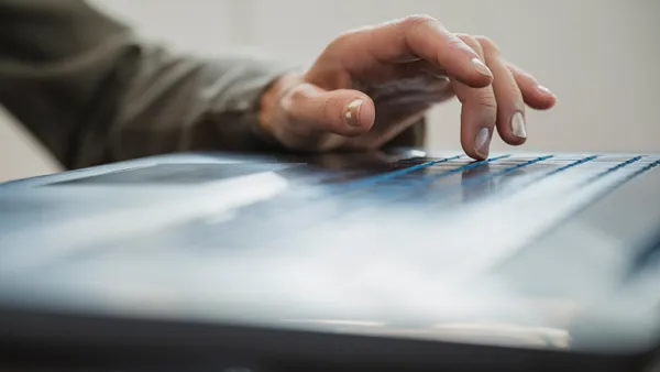 Female hand typing and using black laptop computer.