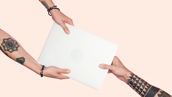 Tattooed people pulling laptop on a light beige background.