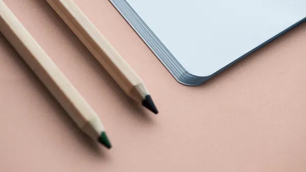Notebook and pencil on a beige background.