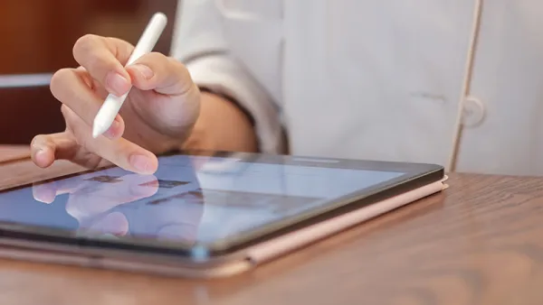 Woman taking notes on a tablet.
