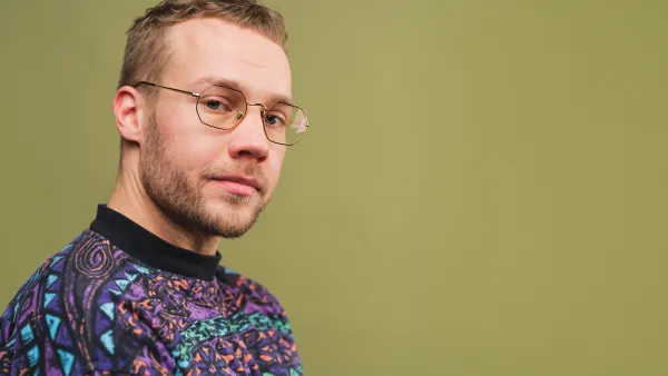 Mies silmälaseissa vihreällä tautalla