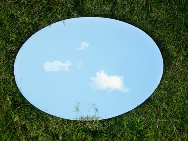 A round mirror on the grass