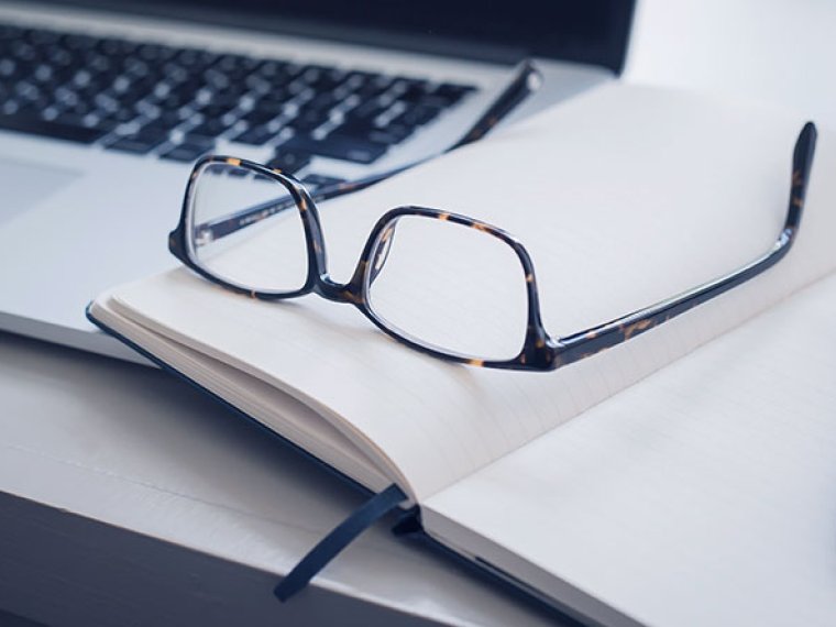 Laptop keyboard, notes and glasses