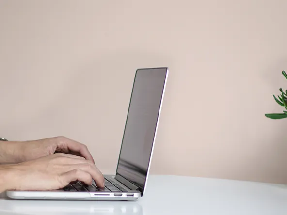 Laptop and a light beige wall.