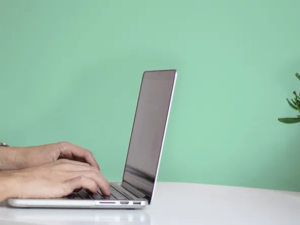 Laptop and a light green wall.
