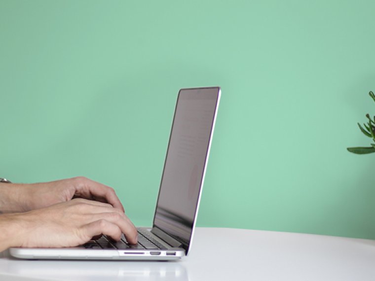 Laptop and a light green wall.
