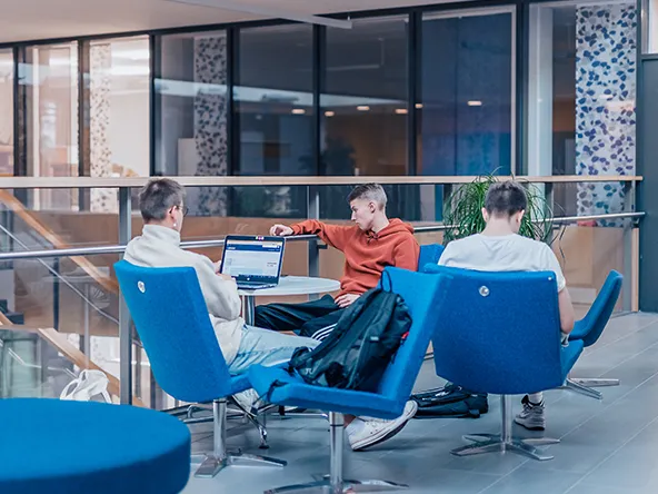 Opiskelijoita istuu sinisillä nojatuoleilla LABin kampuksella.