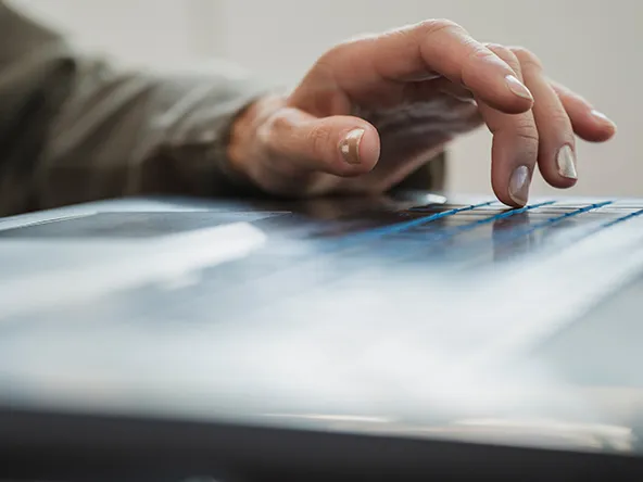 Female hand typing and using black laptop computer.