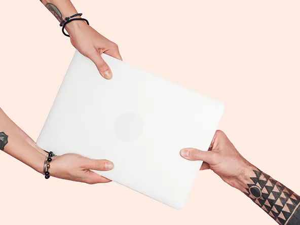 Tattooed people pulling laptop on a light beige background.