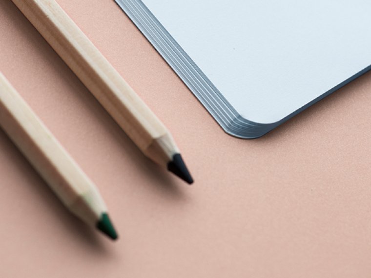 Notebook and pencil on a beige background.