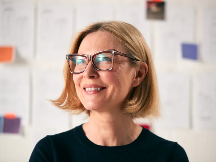 portrait-of-mature-woman-standing-in-front-of-desi
