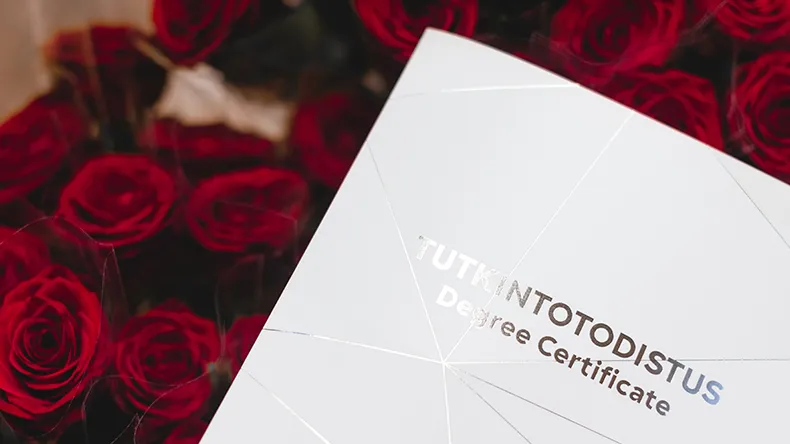 LABin tutkintotodistus ruusujen päällä.