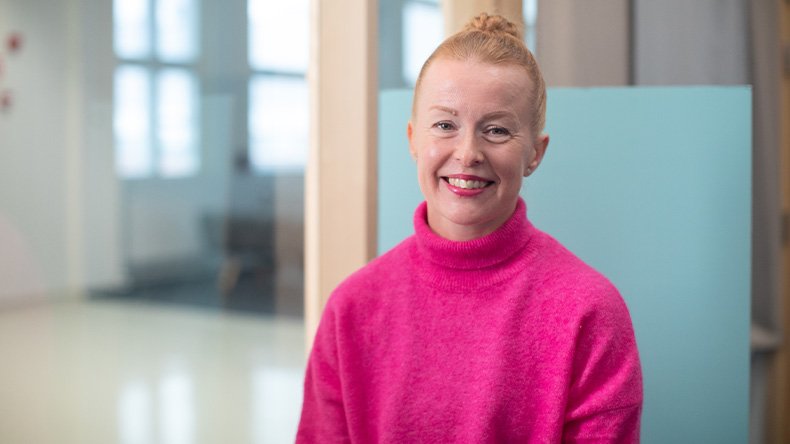 Kuvassa YAMK-opiskelija Jenni Hämäläinen istuu kampuksen käytävälle avautuvan ikkunan edessä.