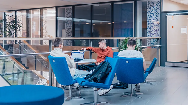 Opiskelijoita istuu sinisillä nojatuoleilla LABin kampuksella.