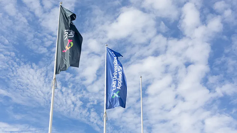 LABin ja LUTin liput liehuvat salossa sinistä taivasta vasten