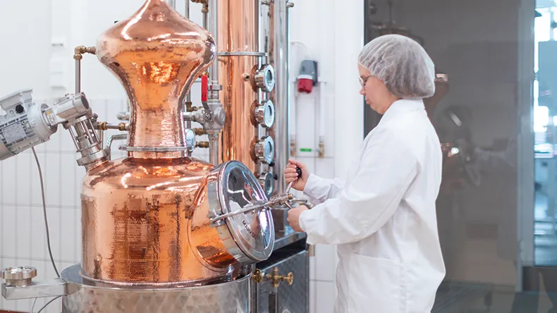 Nainen laboratoriossa uuttolaitteen edessä