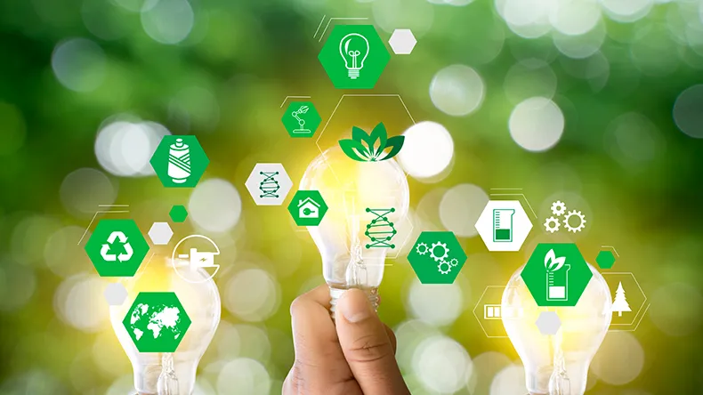 Käsi ja polttimo vihreällä taustalla.