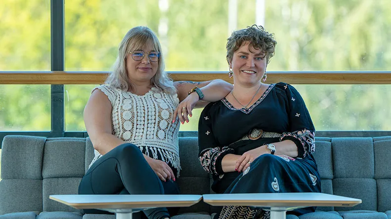 Minna Ahlsten ja Ilona Tuomi istumassa sohvalla 