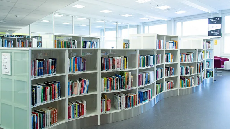 Lahden kirjaston kirjoja valkoisissa kaarevissa hyllyissä