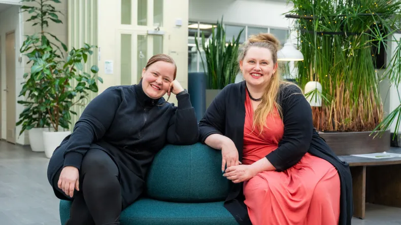 Kaksi opiskelijaa kampuksen aulassa